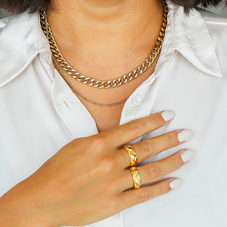 a woman wearing a gold chain necklace and ring
